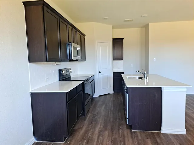 a kitchen with a sink and wooden cabinets
