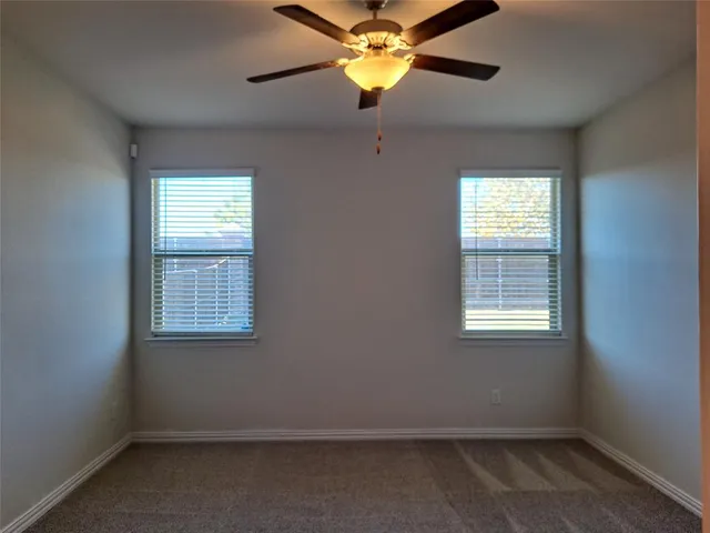 an empty room with a window and a fan