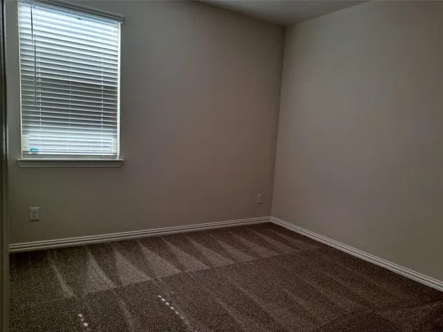 a view of a small space with wooden floor and a window