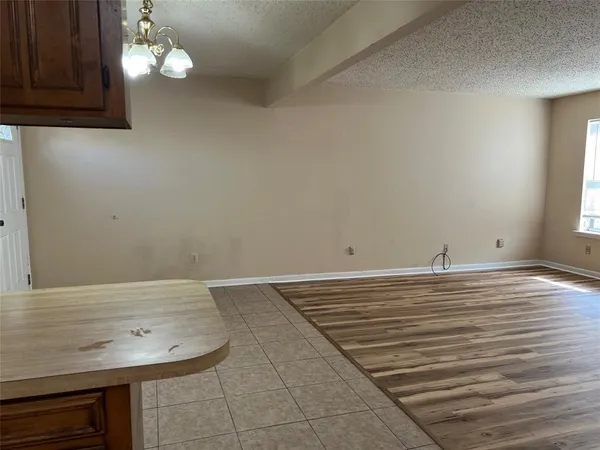 a view of a room with wooden floor and chandelier