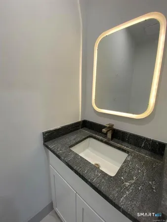 a bathroom with a granite countertop sink and a mirror