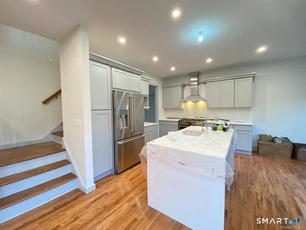 a kitchen with a refrigerator sink and wooden cabinets