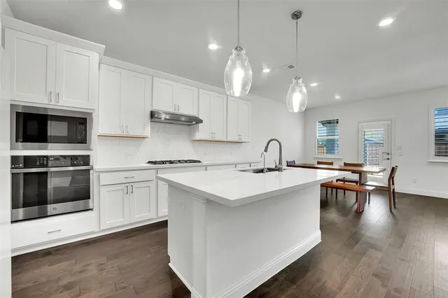 a kitchen with a sink stove and microwave