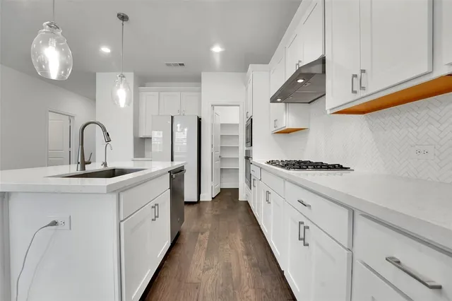 a kitchen with white cabinets and chandelier