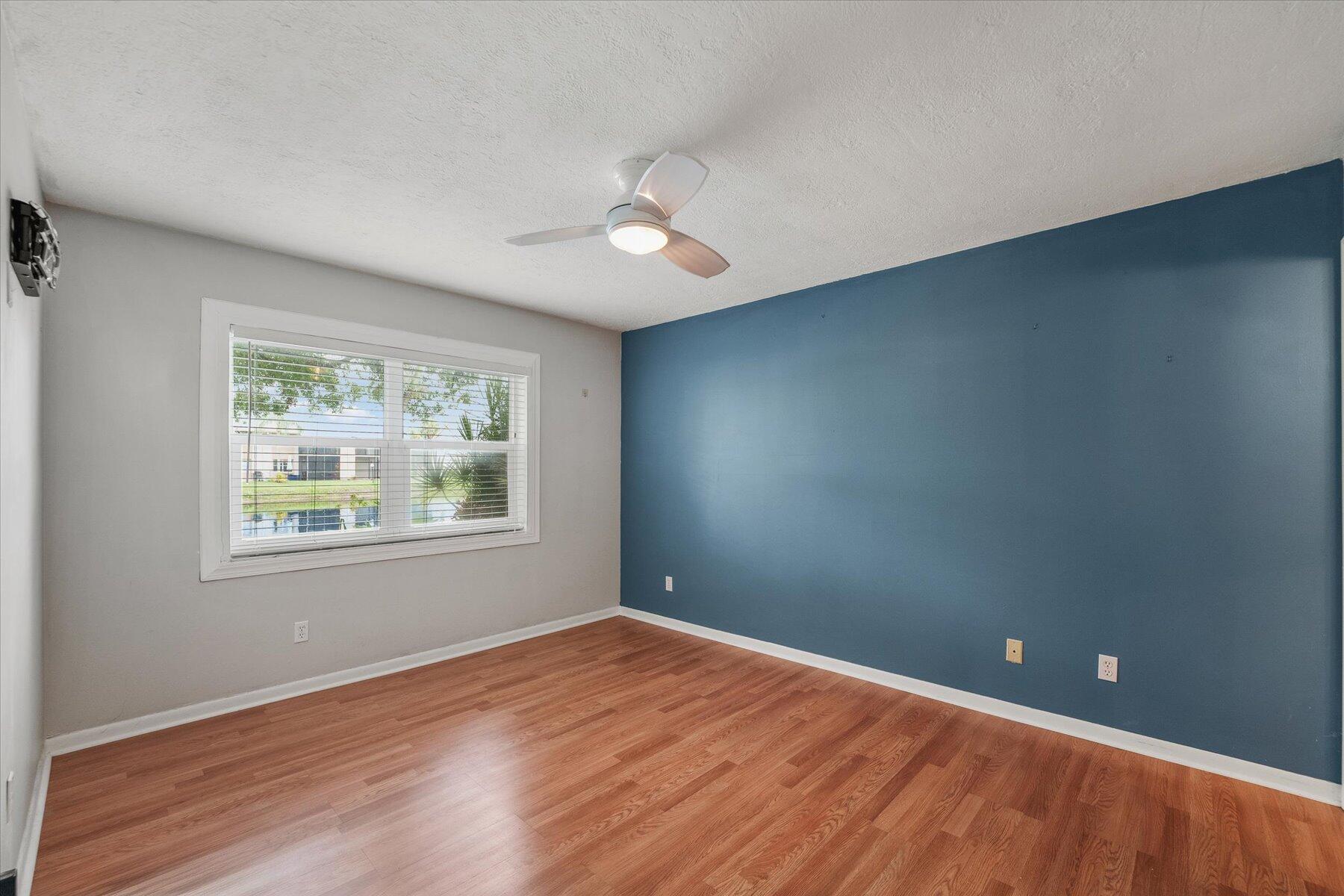 3151 Southeast Aster Lane, Unit 1302 Stuart, FL 34994 - Photo 13 of 23 an empty room with wooden floor and windows