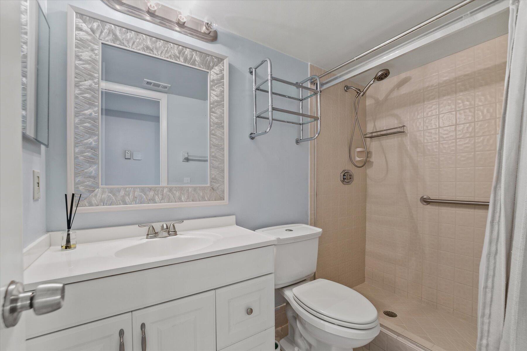 3151 Southeast Aster Lane, Unit 1302 Stuart, FL 34994 - Photo 20 of 23 a bathroom with a sink toilet and shower