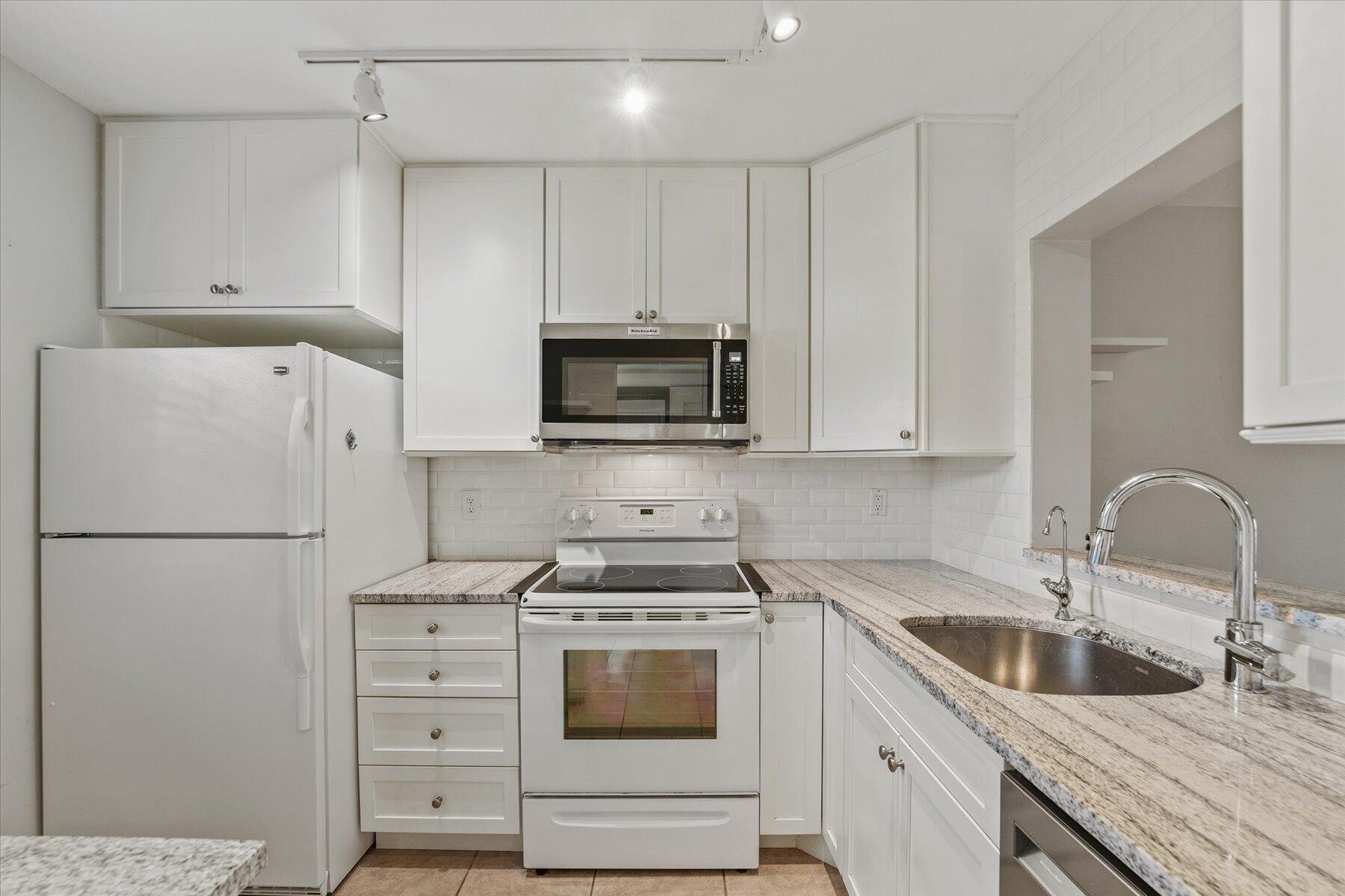 3151 Southeast Aster Lane, Unit 1302 Stuart, FL 34994 - Photo 9 of 23 a kitchen with cabinets appliances a sink and a counter top