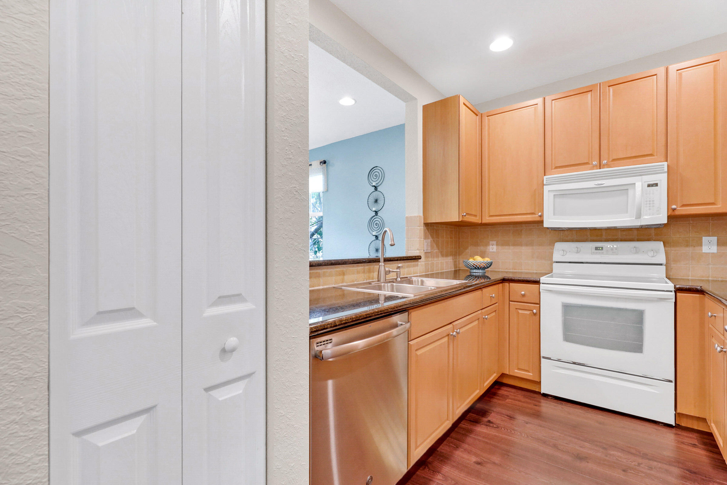 1582 Grande Cull Way Jupiter, FL 33458 - Photo 18 of 75 a kitchen with stainless steel appliances granite countertop a sink and cabinets with wooden floor