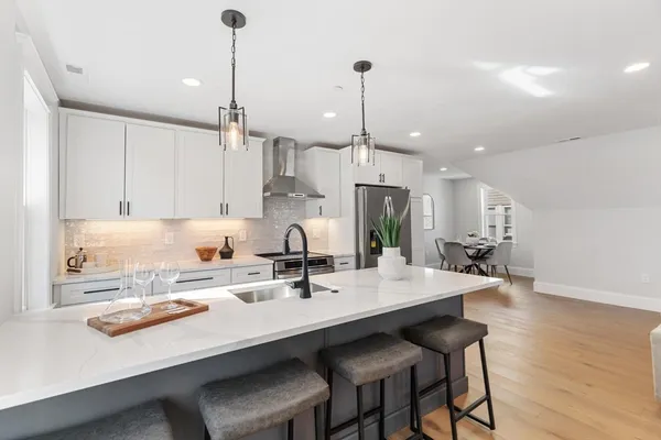 a kitchen with kitchen island a sink dining table and chairs