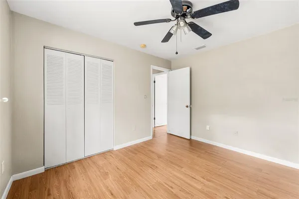 a view of empty room with wooden floor