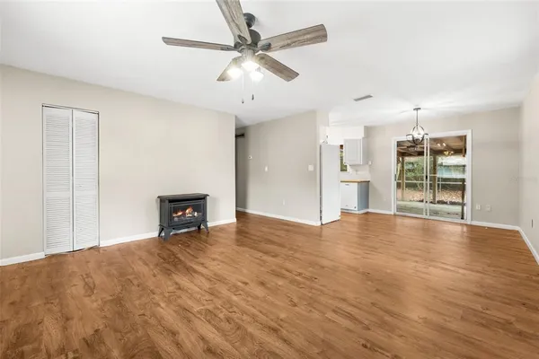 a view of an empty room with a window and a kitchen