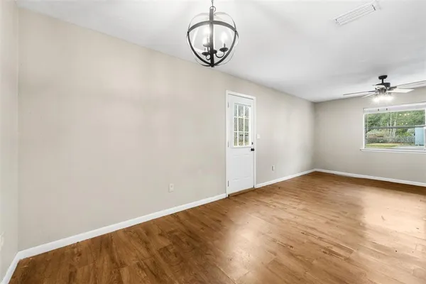 a view of an empty room with a window and wooden floor