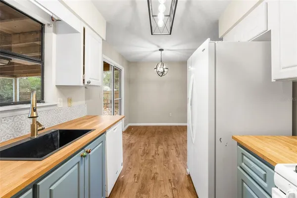 a kitchen with granite countertop a sink a counter space and cabinets