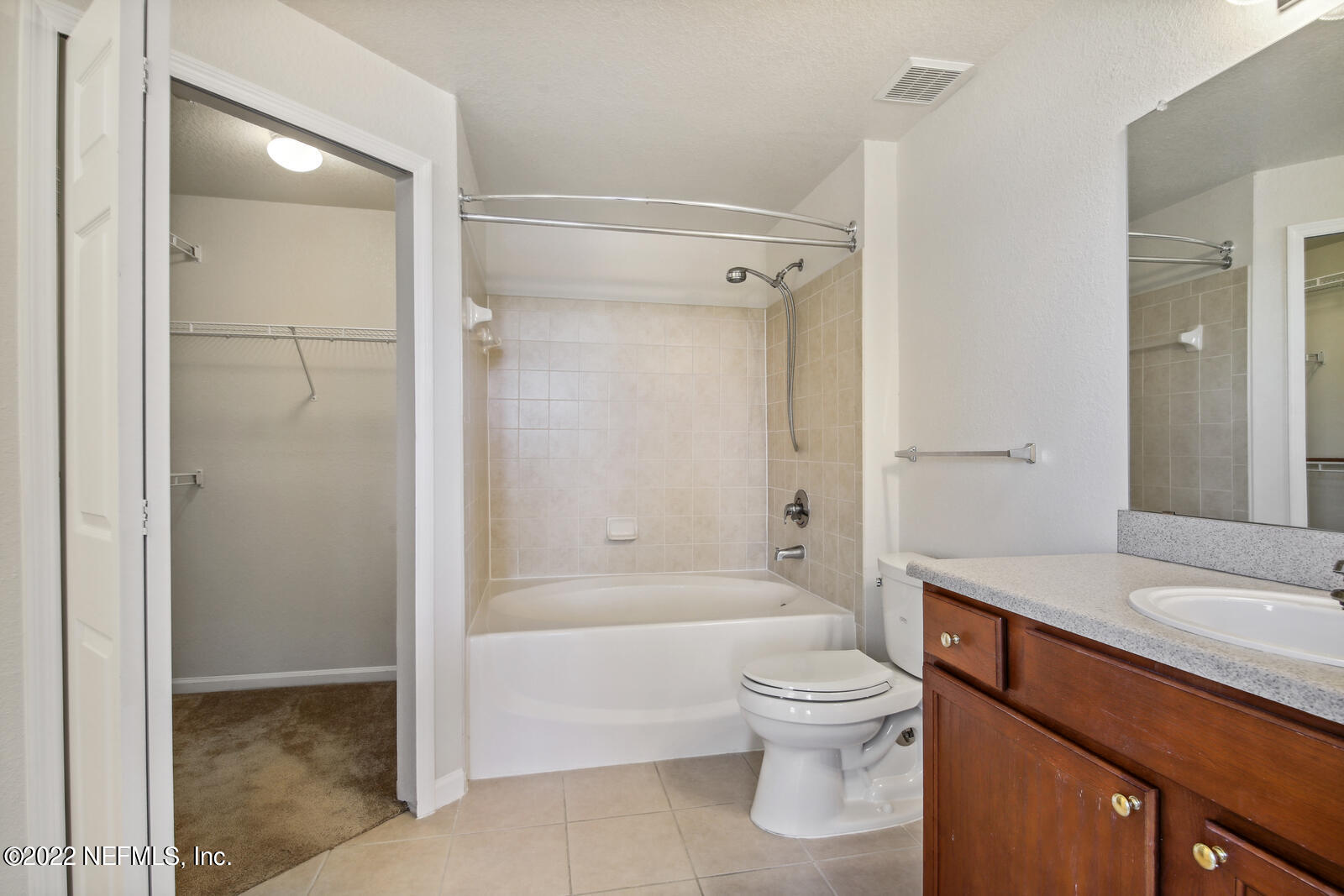 8550 Touchton Road, Unit 1438 Jacksonville, FL 32216 - Photo 18 of 37 a bathroom with a granite countertop toilet a sink and a bathtub