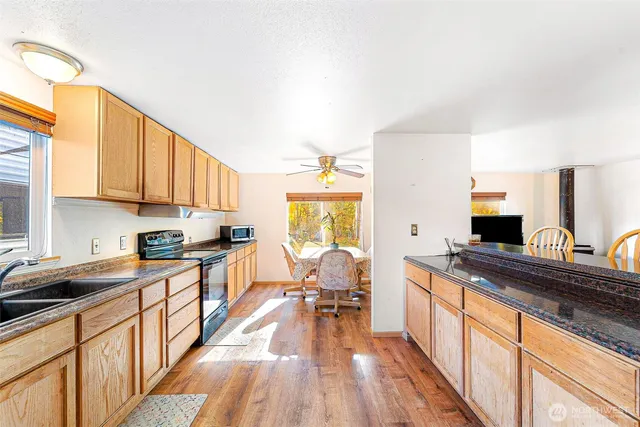 a large kitchen with stainless steel appliances granite countertop a stove and a sink