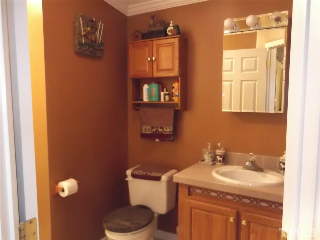 299 J C Lunsford Road Roxboro, NC 27574 - Photo 14 of 25 a bathroom with a granite countertop toilet sink and mirror