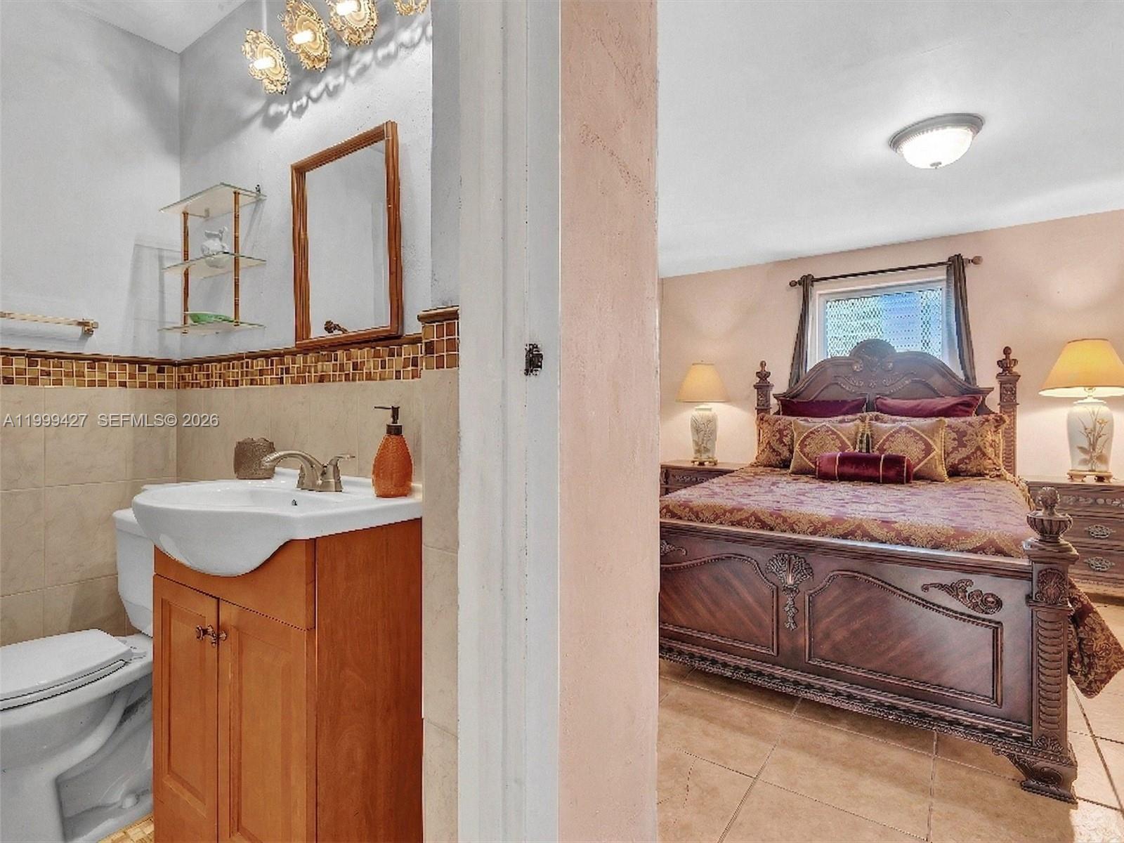 10 Southwest 72nd Avenue Miami, FL 33144 - Photo 16 of 35 a en suite bathroom with a granite countertop sink and a mirror