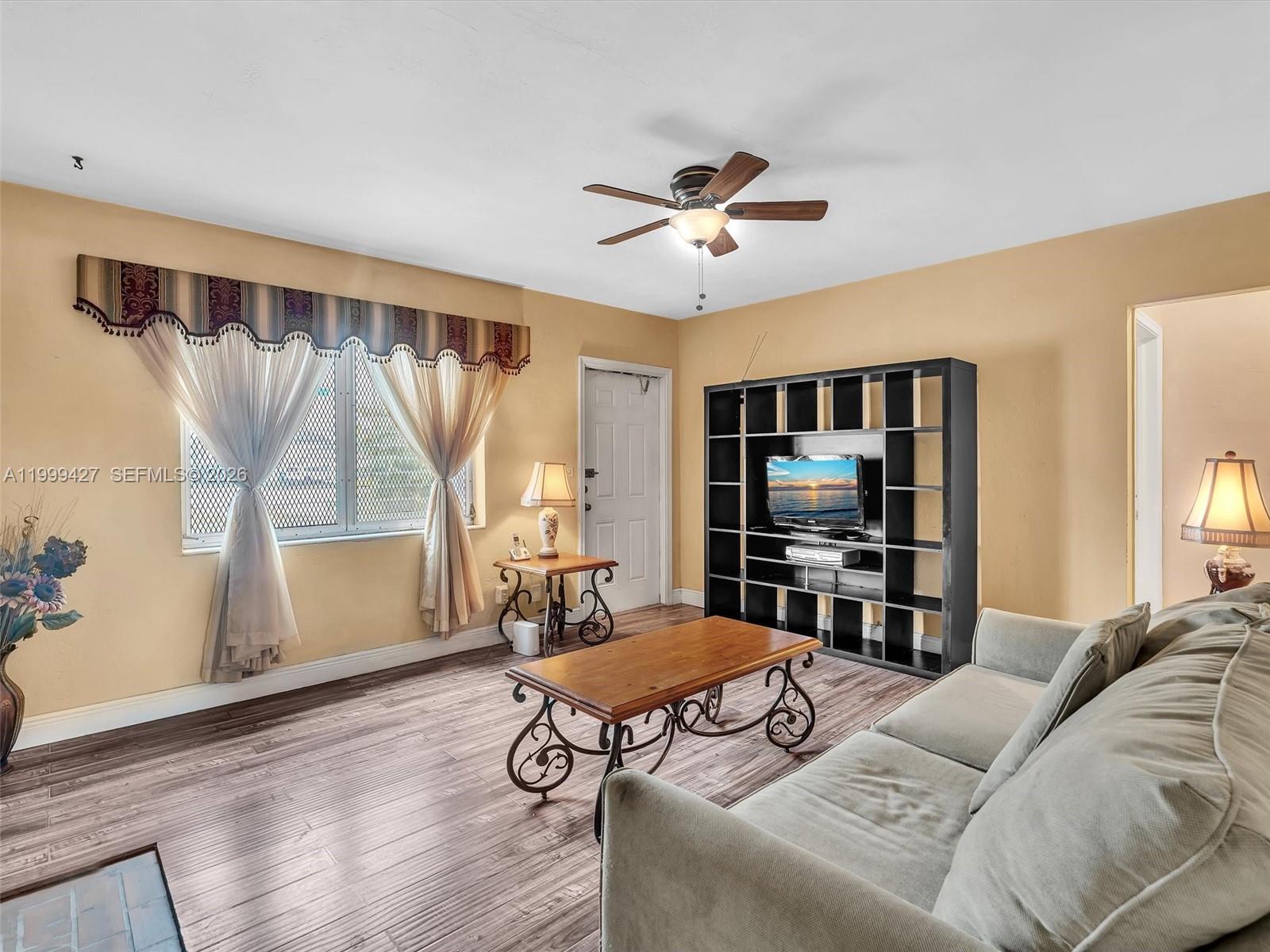 10 Southwest 72nd Avenue Miami, FL 33144 - Photo 6 of 35 a living room with furniture a flat screen tv and a window
