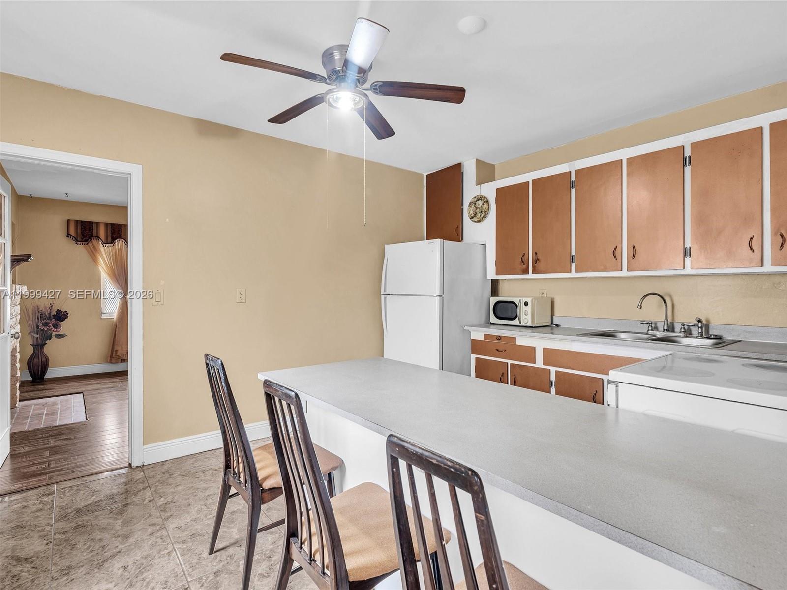 10 Southwest 72nd Avenue Miami, FL 33144 - Photo 9 of 35 a kitchen with a dining table chairs and refrigerator