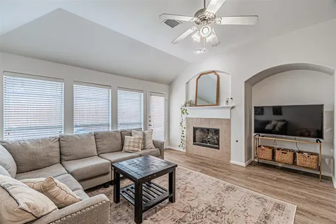 a living room with furniture a fireplace and a flat screen tv