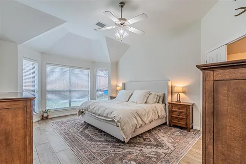 a bedroom with a large bed a chandelier and a window