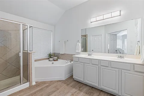 a bathroom with a sink a tub and a mirror