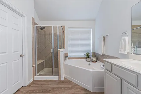 a bathroom with a tub sink shower and mirror