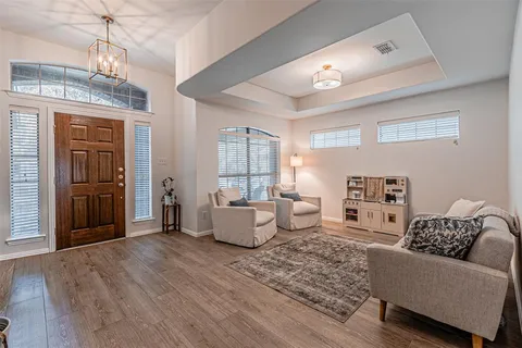 a living room with furniture and a chandelier
