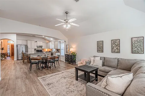 a living room with furniture kitchen view and a dining table