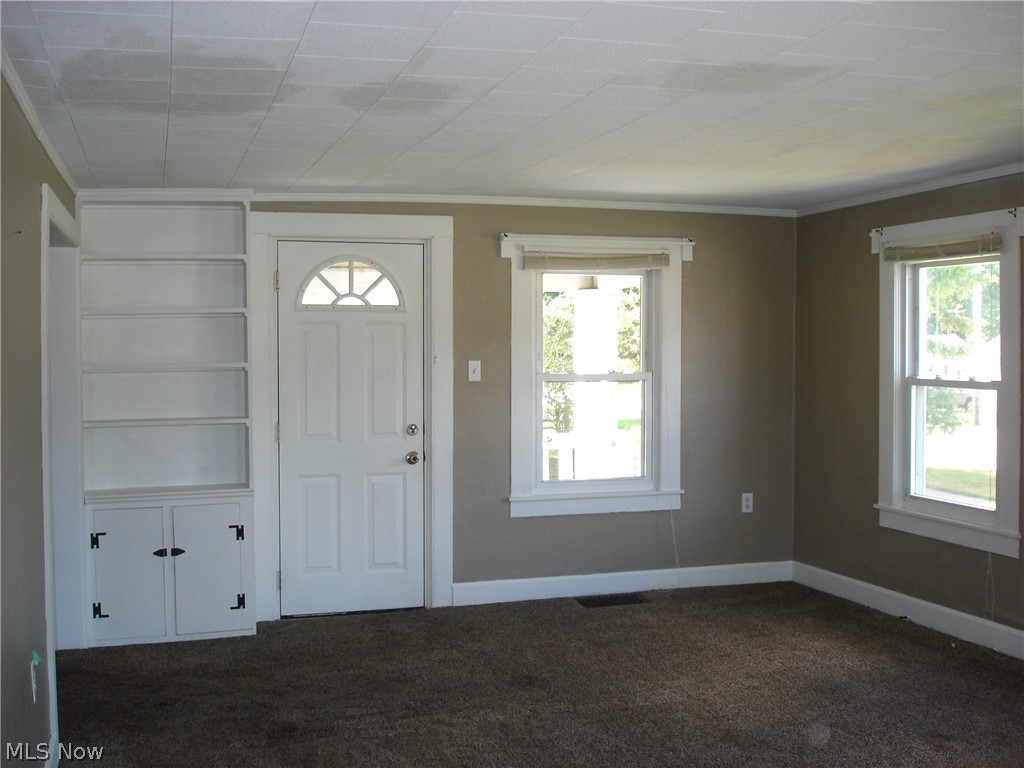 77 South Maple State Road Orwell, OH 44076 - Photo 3 of 30 Living room with built in bookshelf & cupboard