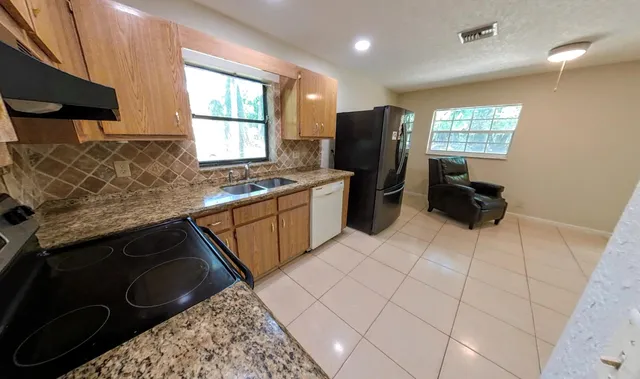 a kitchen with stainless steel appliances granite countertop a sink stove and cabinets