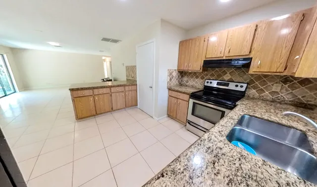 a kitchen with stainless steel appliances granite countertop a stove a sink and a refrigerator