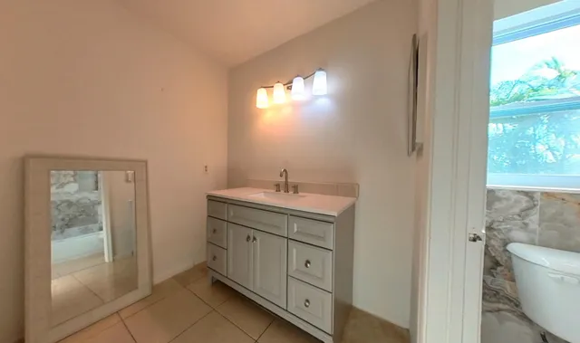 a spacious bathroom with a double vanity sink a toilet and a shower