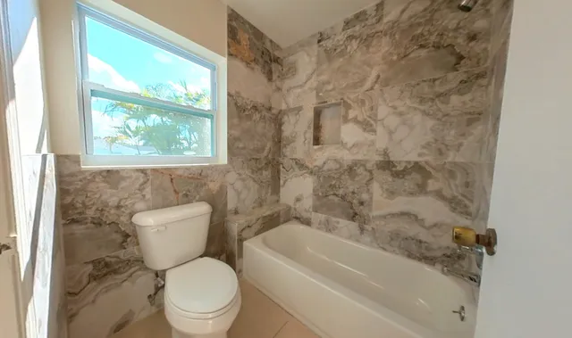 a white toilet sitting next to a bath tub