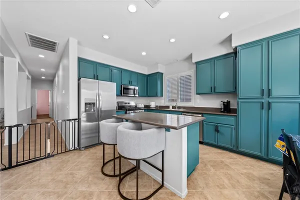 a kitchen with cabinets and chairs