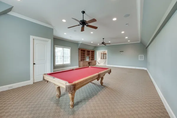 a room with pool table and windows