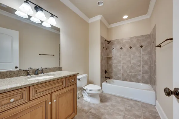 a bathroom with a granite countertop sink a toilet and bathtub