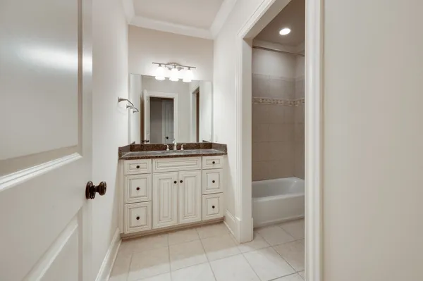 a bathroom with a granite countertop sink a mirror and a bathtub
