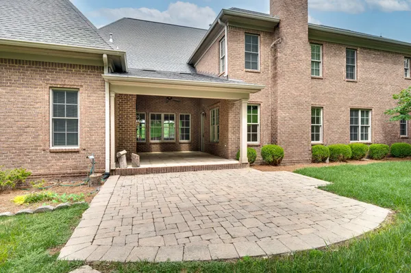 a view of a house with a big yard and large trees