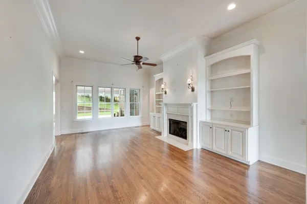 a view of empty room with wooden floor and fireplace