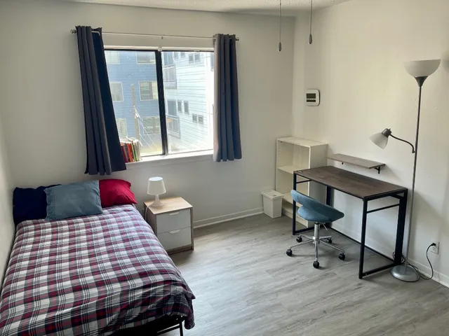 a bedroom with a bed a flat screen tv and dresser