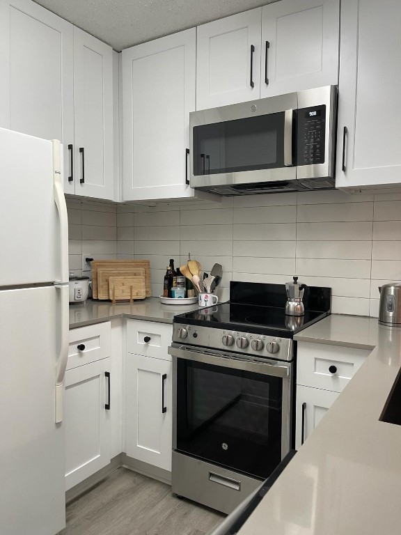 2510 San Gabriel Street, Unit 301 Austin, TX 78705 - Photo 6 of 22 a kitchen with stainless steel appliances granite countertop white cabinets a stove a microwave and a refrigerator
