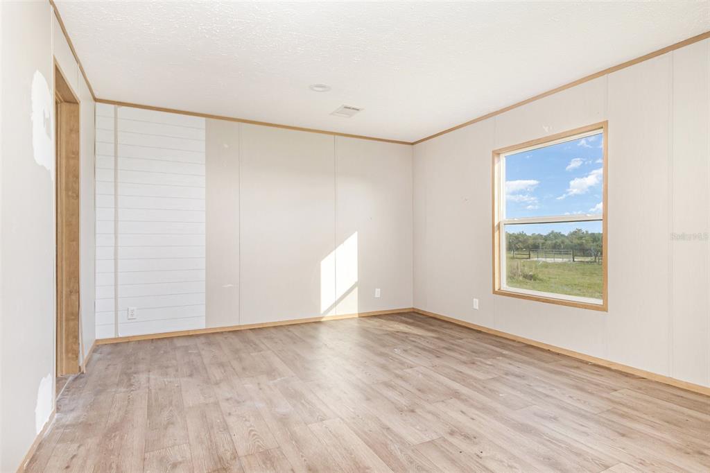 16423 Northwest 262nd Street Okeechobee, FL 34972 - Photo 16 of 30 a view of an empty room with wooden floor and a window