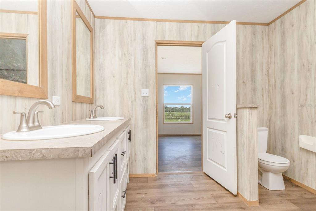 16423 Northwest 262nd Street Okeechobee, FL 34972 - Photo 17 of 30 a bathroom with a sink a toilet and a mirror