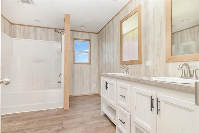 a bathroom with a sink a mirror and a shower