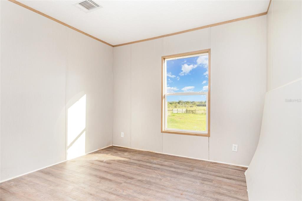16423 Northwest 262nd Street Okeechobee, FL 34972 - Photo 20 of 30 a view of an empty room with wooden floor and a window