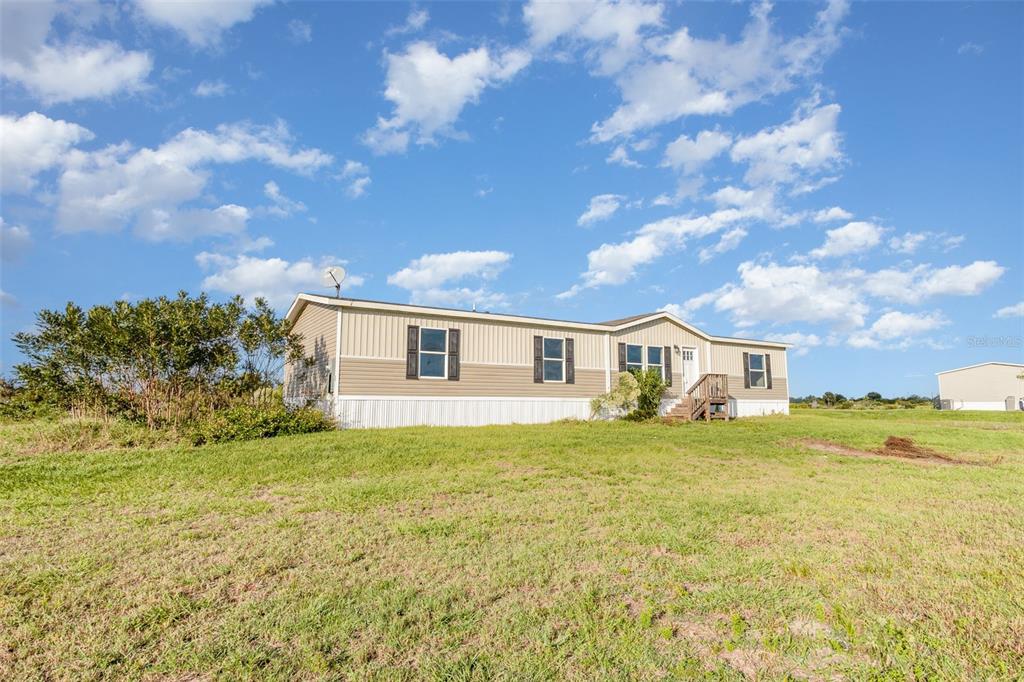 16423 Northwest 262nd Street Okeechobee, FL 34972 - Photo 2 of 30 a front view of a house with a yard