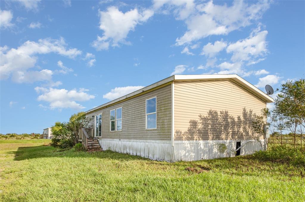 16423 Northwest 262nd Street Okeechobee, FL 34972 - Photo 27 of 30 a view of backyard with swimming pool and green space