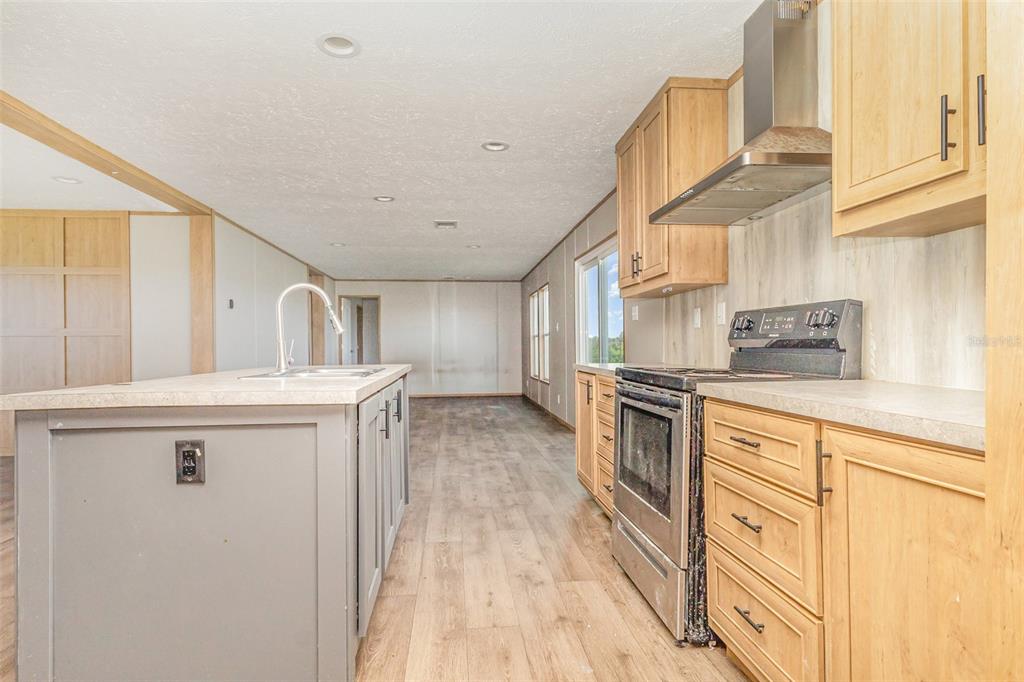 16423 Northwest 262nd Street Okeechobee, FL 34972 - Photo 10 of 30 a kitchen with stainless steel appliances granite countertop a sink a stove and a refrigerator