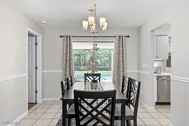 a dining room with furniture a chandelier and window